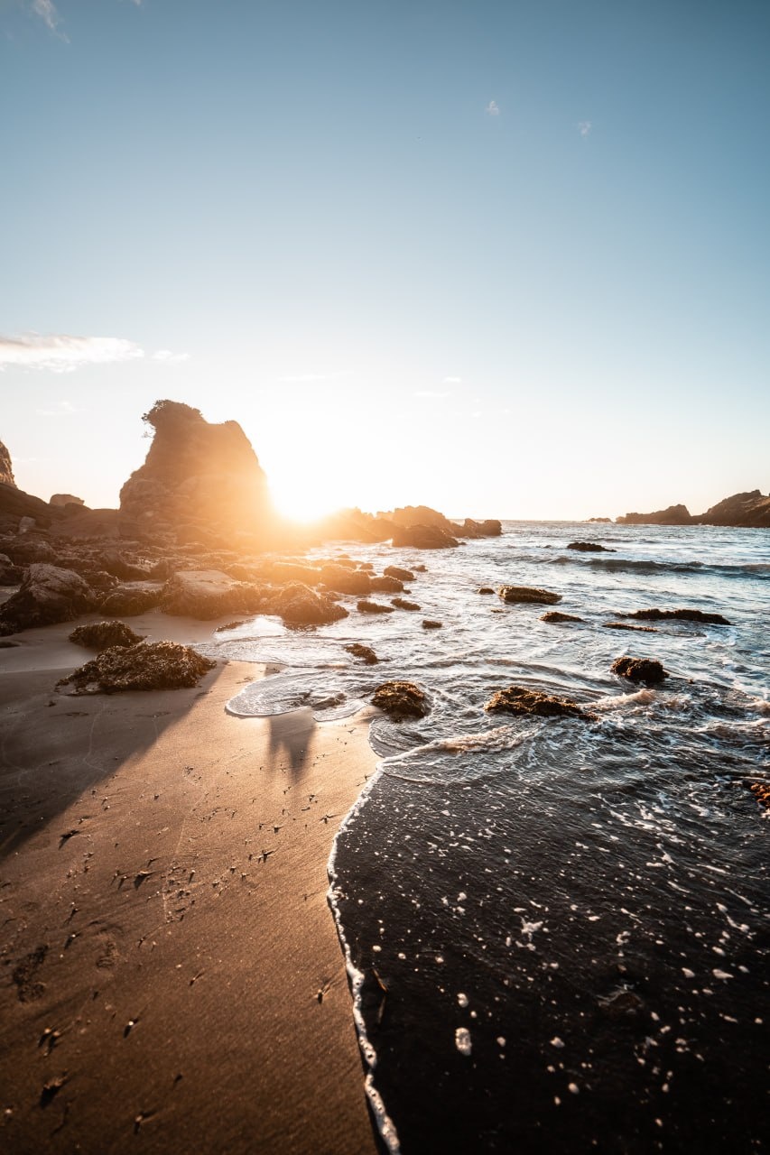 Golden hour beach sunset with rocks